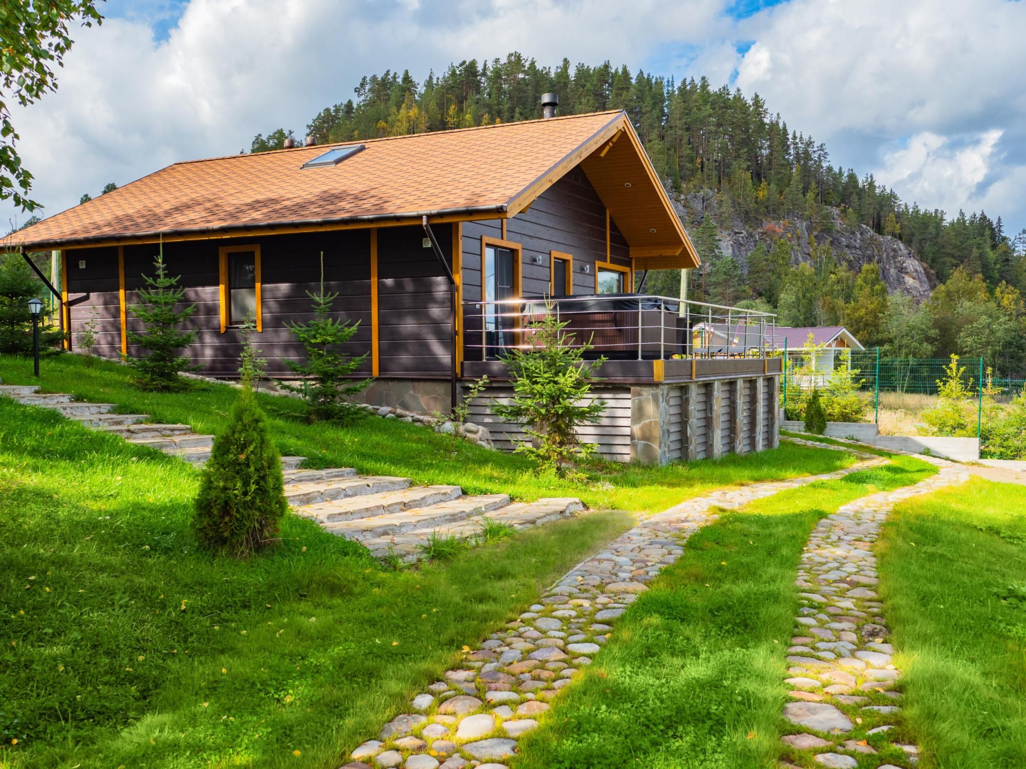 Luxury homes exterior. Houses in suburb at summer in north nature. Luxury house with nice landscape. Suburban luxury homes exterior in wood. Scandinavian style cottage at foot of a cliff.