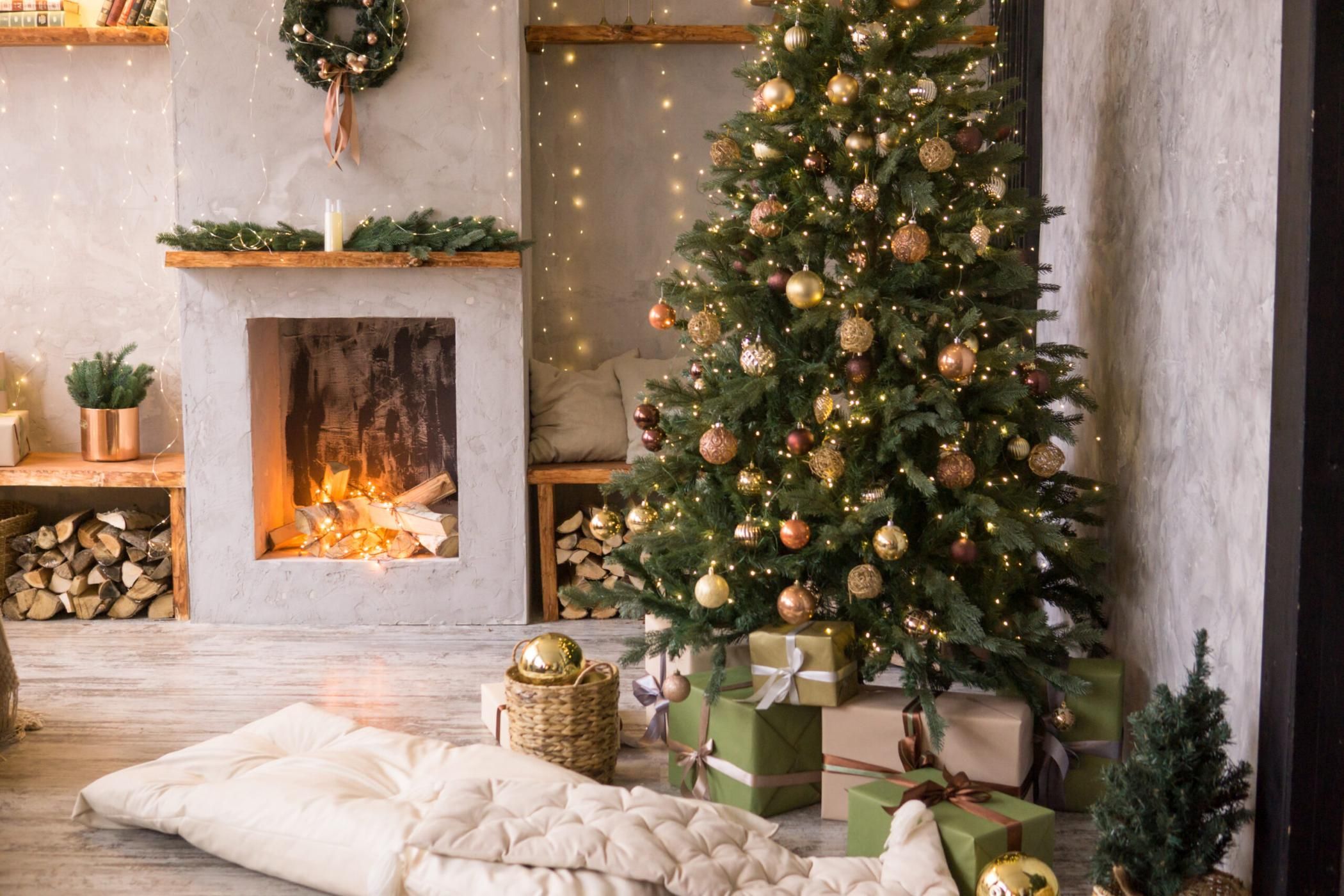 The interior of the Scandinavian-style living room, decorated for the Christmas holidays. Christmas tree next to the fireplace