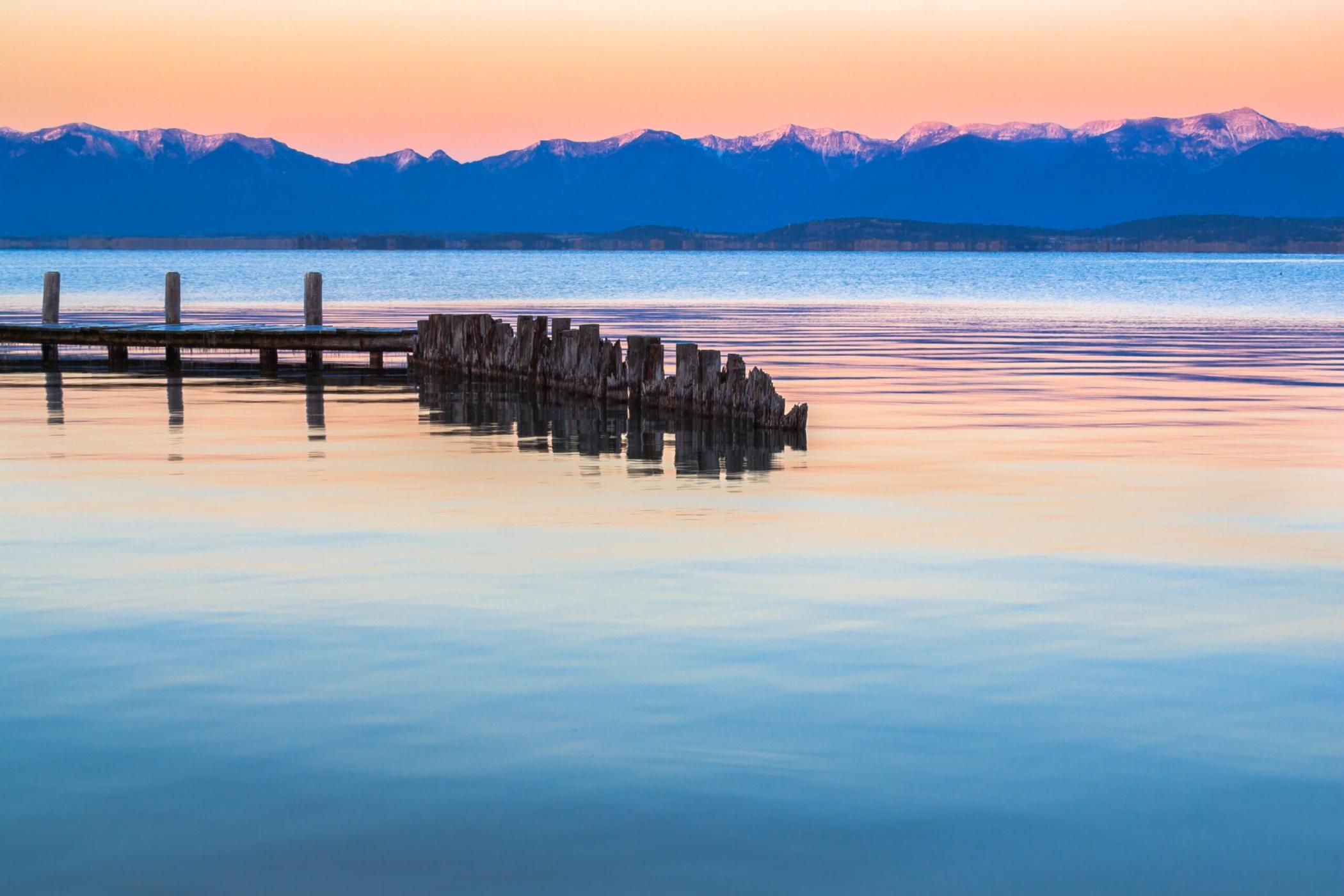 Sunset colors surround an old dock on Flathead Lake, Montana. This photo was my first big commercial sale way back in November of 2002. I shot this one with 6 megapixel Canon D60 which was a cutting-edge camera for that time. The advertisements that featured this image disappeared years ago but I still use this one when I am teaching Adobe Photoshop Lightroom workshops. What you can't see in this version are the huge green and magenta bands of chromatic aberration that surround the dock and the pylons in the original capture. Of all the advances in Adobe Photoshop Lightroom 4 one of the most amazing has got to be the one-button lateral chromatic aberration removal feature. For a video tutorial on this incredible image repair tool see https://vimeo.com/34692920